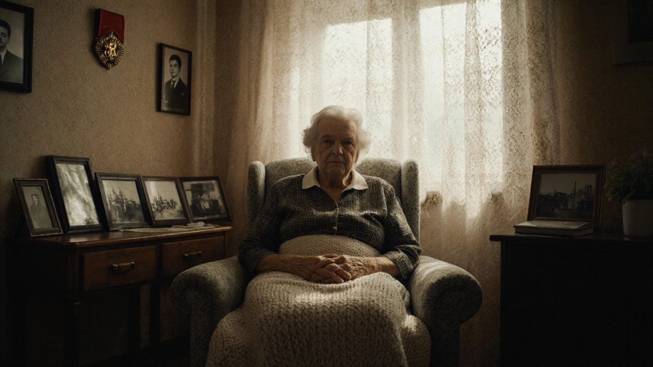 Пожилая женщина в кресле с семейными фото и медалью "Ветеран труда" на стене.